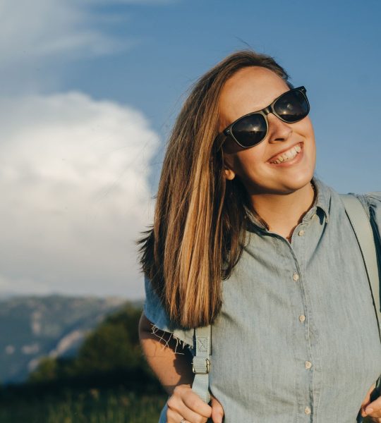 charming-woman-traveler-with-blue-backpack-and-sun-MZ8TE8T.jpg