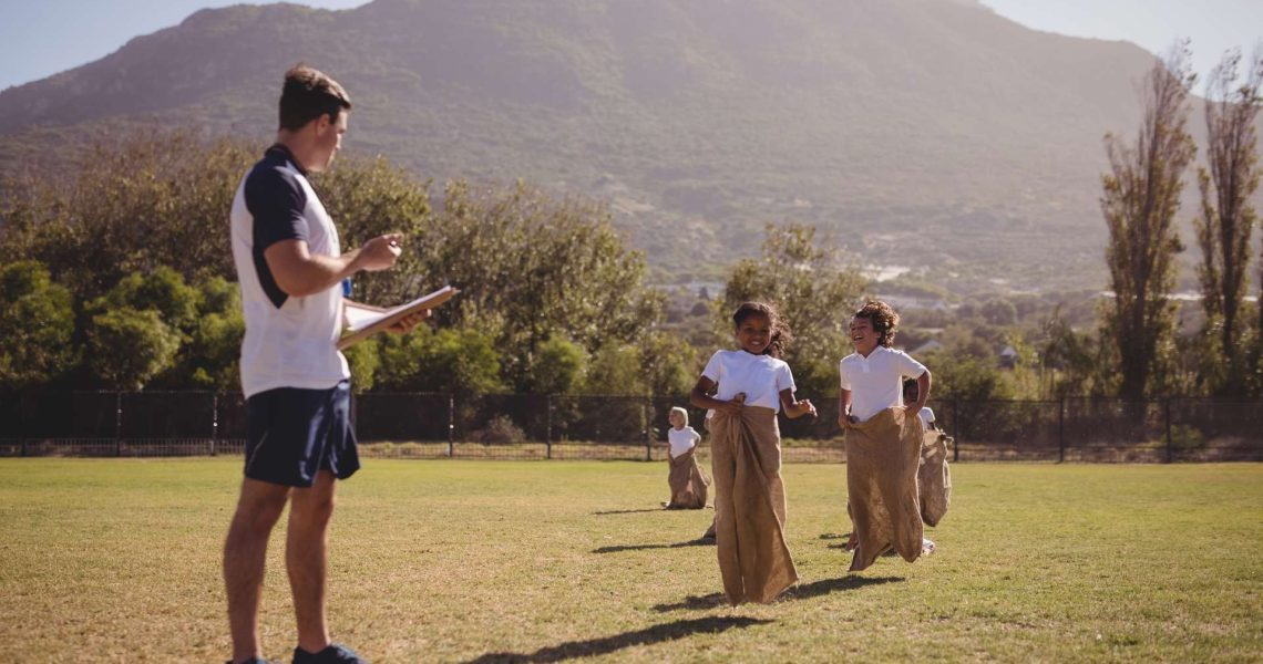 coach-monitoring-schoolgirls-during-sack-race-in-p-UH2WQG6-1.jpg